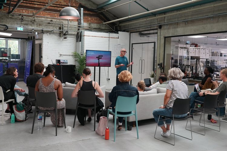 A workshop presenter speaking to a group at Blue Garage
