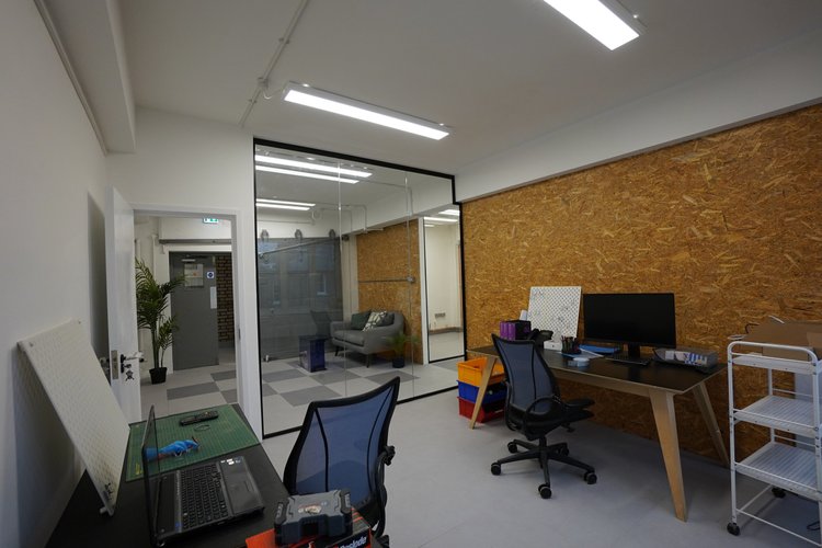Private office with desks beside a glass-fronted room.