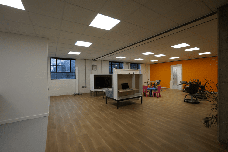 Classroom with children’s furniture, teaching equipment and an orange wall.