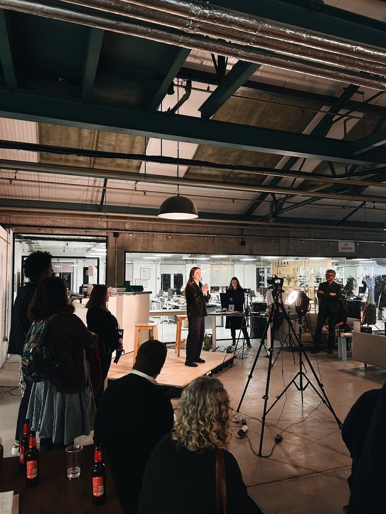 A speaker sharing her experience with an audience at Blue Garage