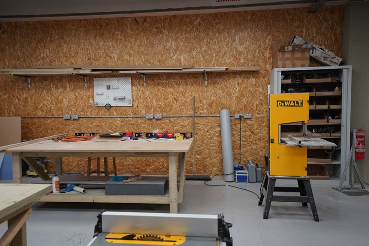 Woodworking benches, hand tools and a yellow DeWalt saw.