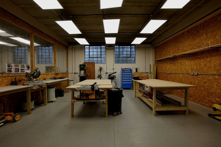 Woodworking workshop with machinery, benches and tool storage.