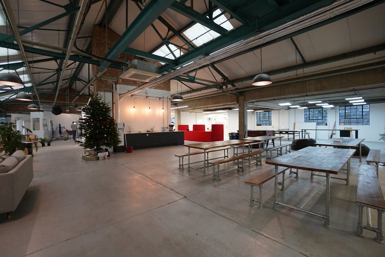 Shared space with long tables, a lounge and a decorated Christmas tree.